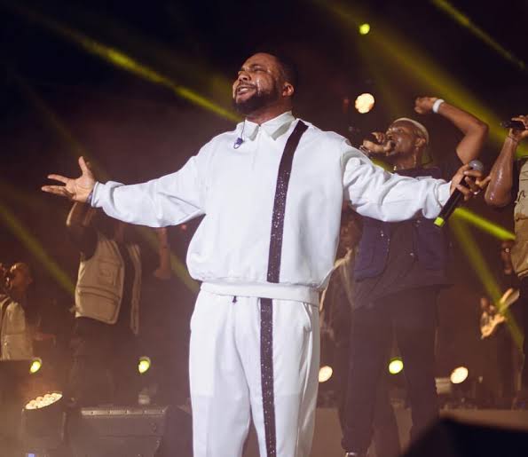 Tim Godfrey performing on stage with a live band